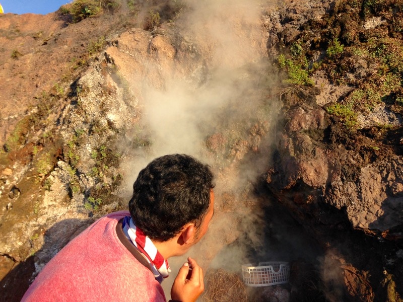 Adi boiling eggs in the steam of Mount Batur, Bali