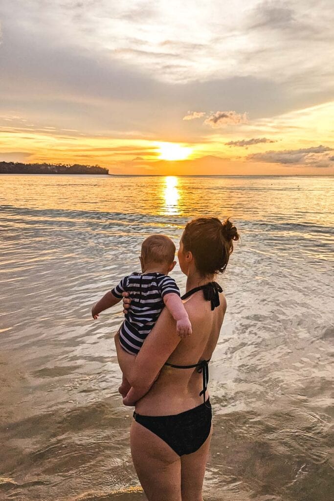 on the beach with a baby in phuket at sunset