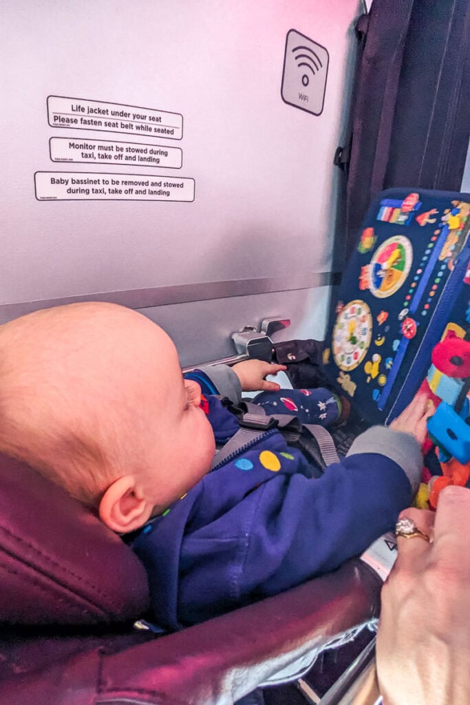 baby playing with busy board on plane